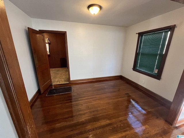 spare room with dark wood-type flooring