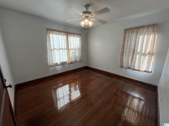 spare room featuring ceiling fan and dark wood-type flooring