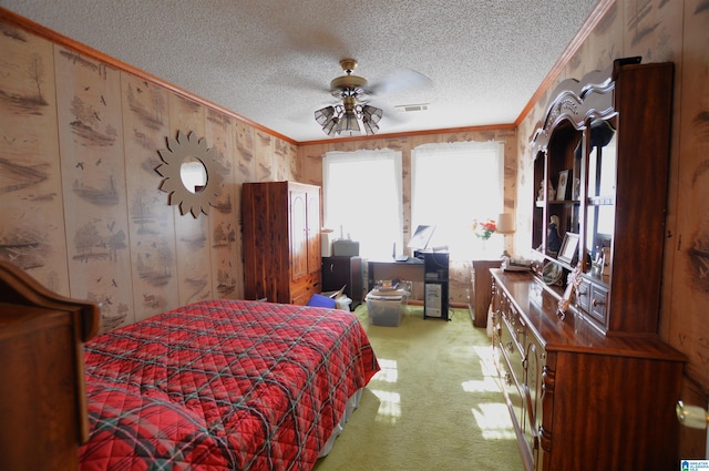 carpeted bedroom with a textured ceiling, ceiling fan, and crown molding