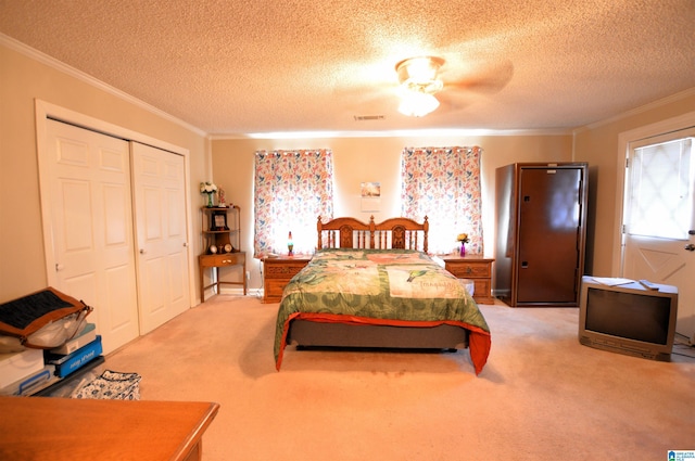 bedroom with a textured ceiling, ceiling fan, light carpet, and a closet