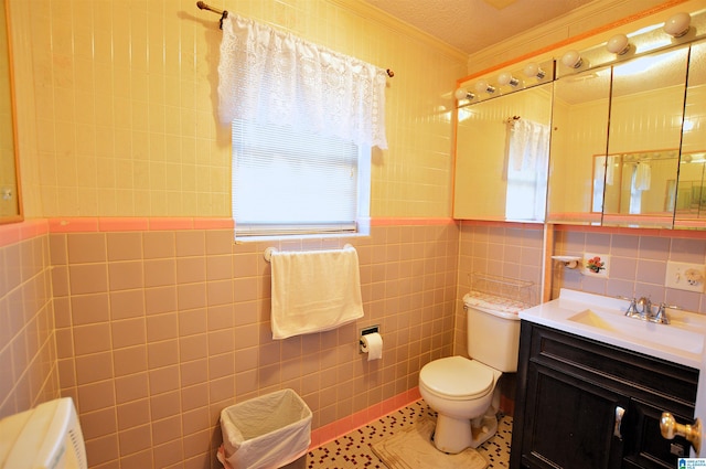 bathroom featuring vanity, tile patterned floors, crown molding, tile walls, and a textured ceiling