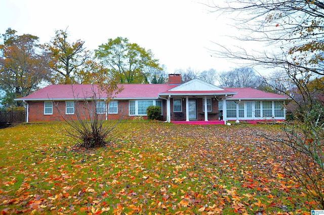 single story home with a sunroom and a front lawn