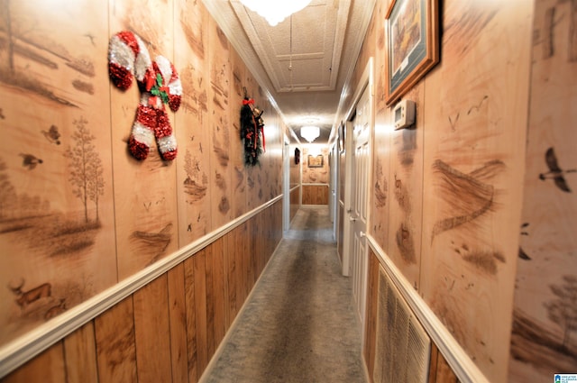 hallway with wood walls and dark carpet