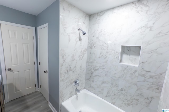 bathroom featuring hardwood / wood-style flooring and tiled shower / bath