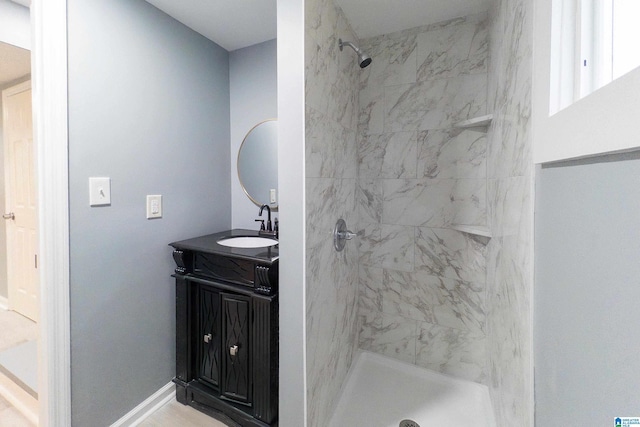 bathroom with vanity and a tile shower