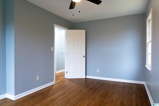 empty room with dark hardwood / wood-style flooring and ceiling fan