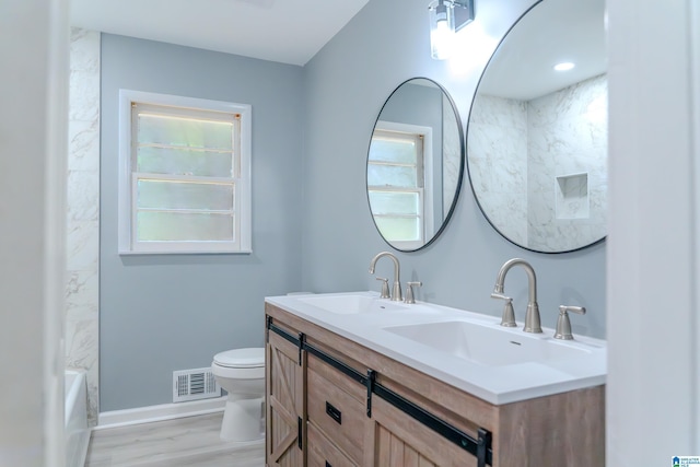 bathroom with hardwood / wood-style floors, vanity, and toilet