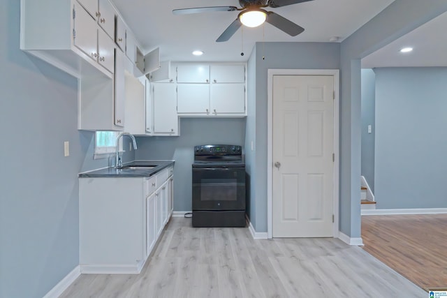 kitchen featuring electric range, light hardwood / wood-style floors, white cabinetry, and sink