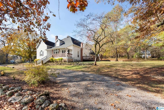 view of side of property with a porch and a lawn