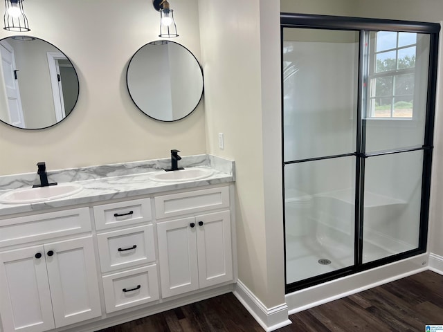 bathroom with hardwood / wood-style flooring, vanity, and a shower with door