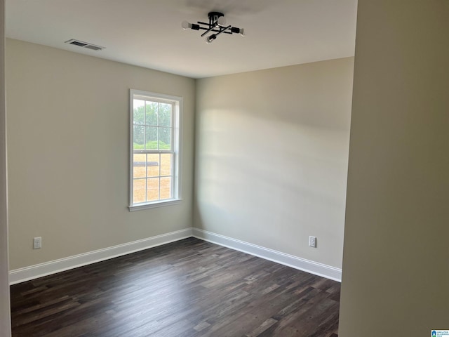 unfurnished room with dark wood-type flooring