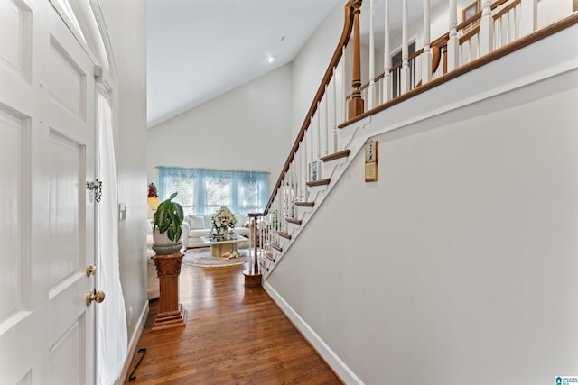 foyer with dark hardwood / wood-style flooring and high vaulted ceiling