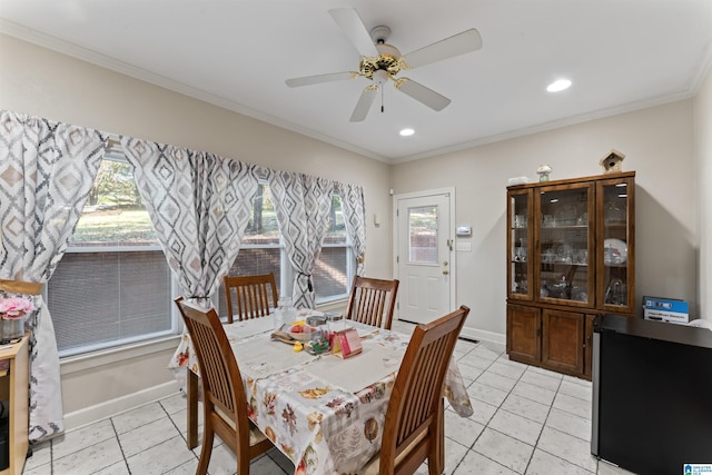 tiled dining room with ceiling fan and crown molding