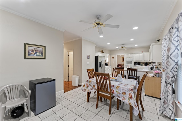 dining area with ceiling fan, light tile patterned flooring, and crown molding