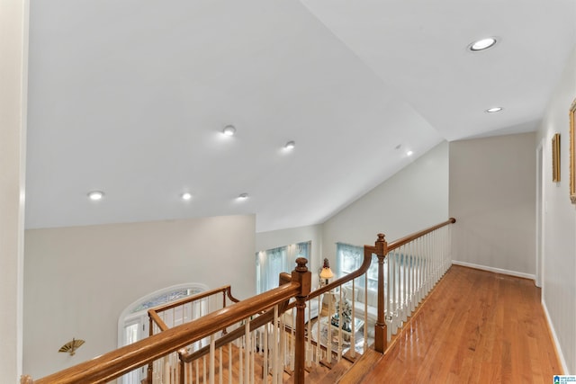 hallway with light hardwood / wood-style floors and vaulted ceiling