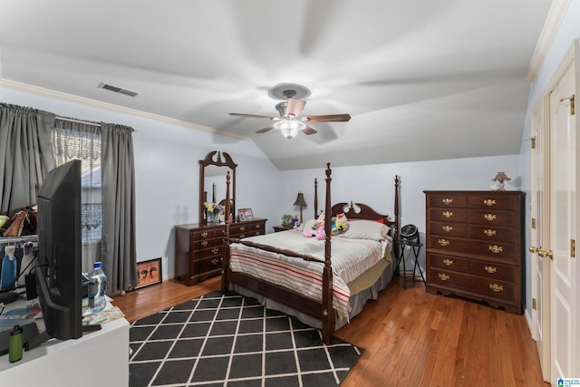 bedroom featuring hardwood / wood-style floors, ceiling fan, crown molding, and vaulted ceiling