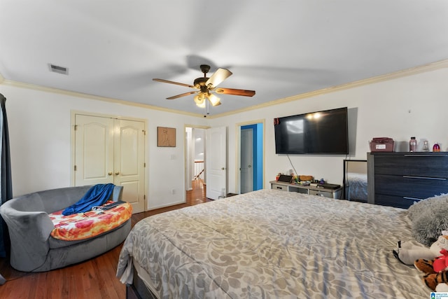 bedroom with ceiling fan, a closet, wood-type flooring, and ornamental molding