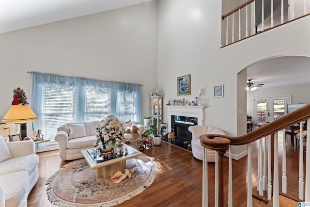 living room with ceiling fan, french doors, a high end fireplace, high vaulted ceiling, and hardwood / wood-style floors