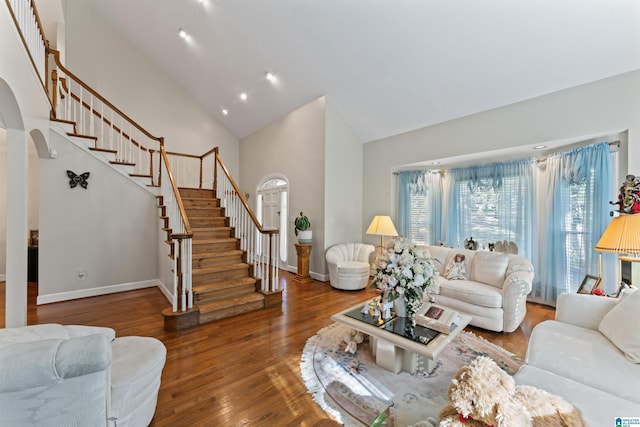 living room featuring wood-type flooring and high vaulted ceiling