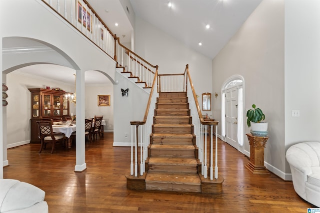 foyer entrance with dark hardwood / wood-style floors, high vaulted ceiling, and crown molding