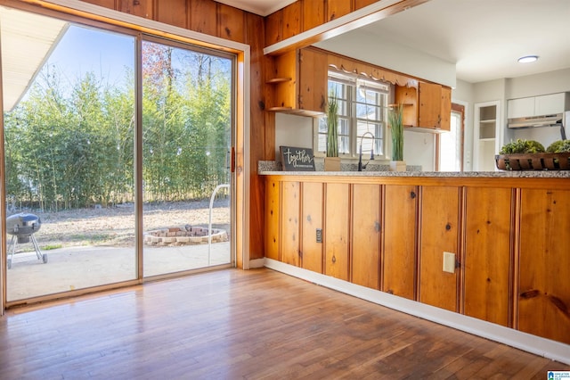 kitchen featuring sink, wooden walls, and light hardwood / wood-style flooring