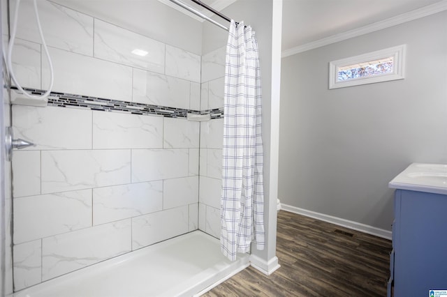 bathroom featuring crown molding, vanity, wood-type flooring, and walk in shower