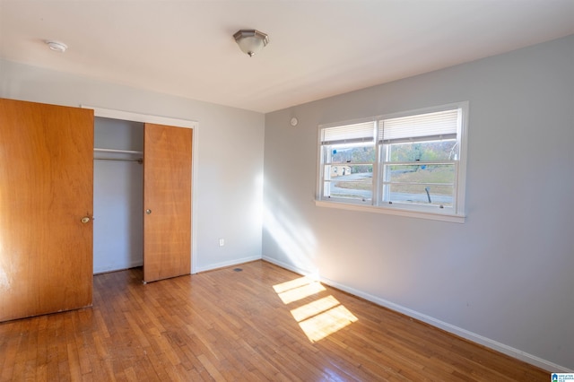 unfurnished bedroom featuring a closet and light wood-type flooring