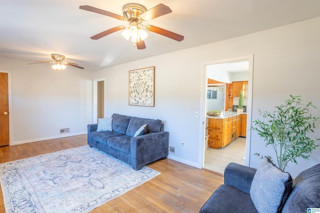 living room with light hardwood / wood-style floors and ceiling fan