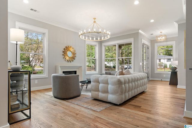 721 Euclid Ave, Mountain Brook, AL 35213 - living area featuring a chandelier, light wood-style floors, crown molding, plenty of natural light, and a fireplace