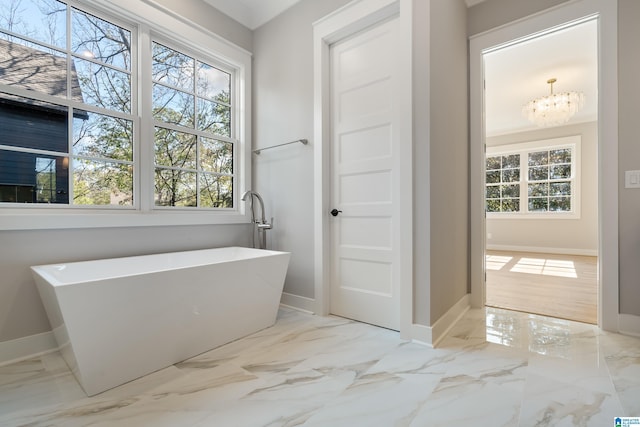 bathroom featuring a washtub and a chandelier