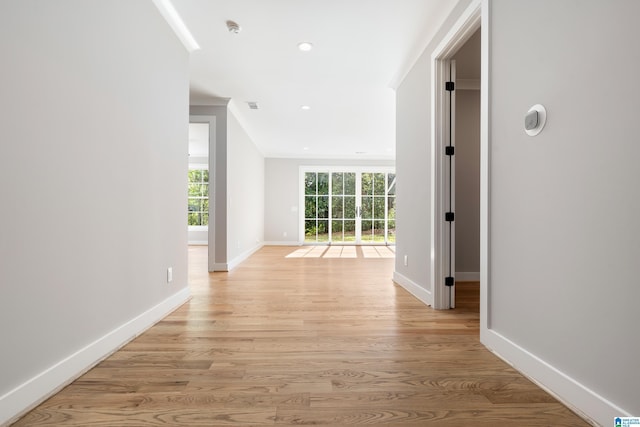 hallway with light hardwood / wood-style floors