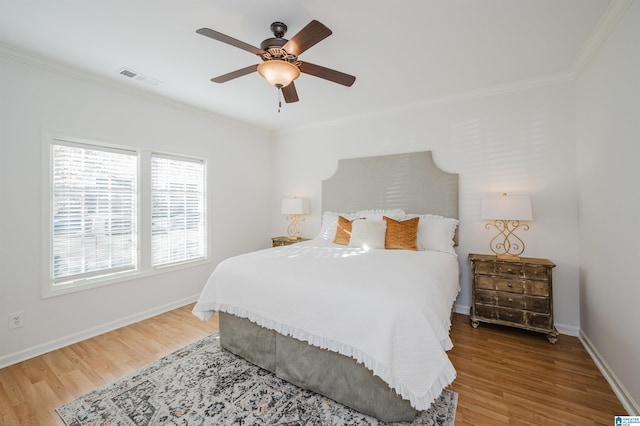 bedroom with ceiling fan, wood-type flooring, and crown molding