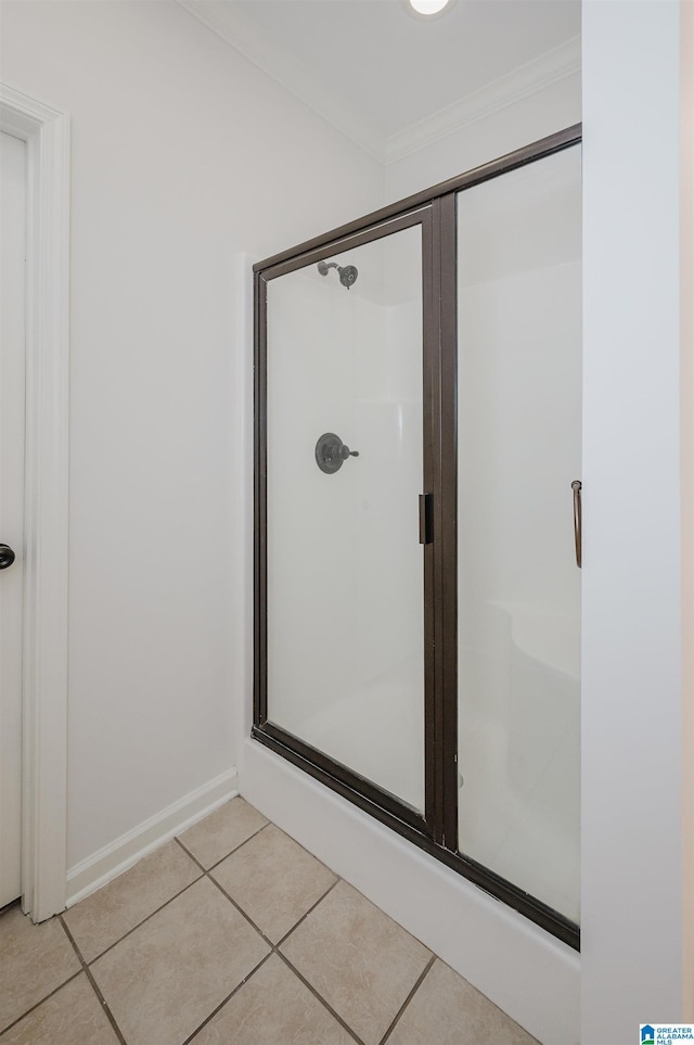 bathroom featuring tile patterned flooring, a shower with door, and crown molding