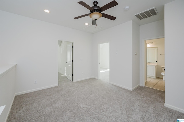 unfurnished bedroom with ensuite bathroom, ceiling fan, and light colored carpet