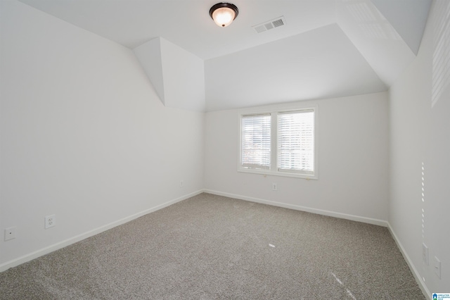 unfurnished room featuring carpet and lofted ceiling