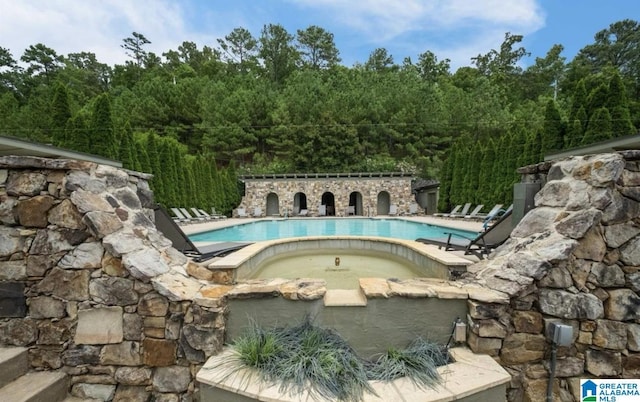 view of swimming pool featuring a hot tub