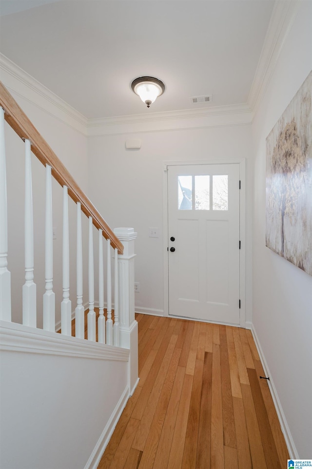 entrance foyer featuring hardwood / wood-style flooring and crown molding