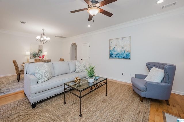 living room featuring ceiling fan with notable chandelier, light hardwood / wood-style floors, and crown molding