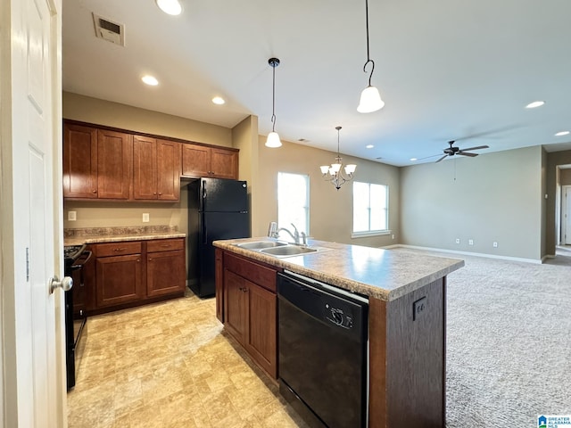 kitchen with ceiling fan with notable chandelier, sink, black appliances, pendant lighting, and an island with sink