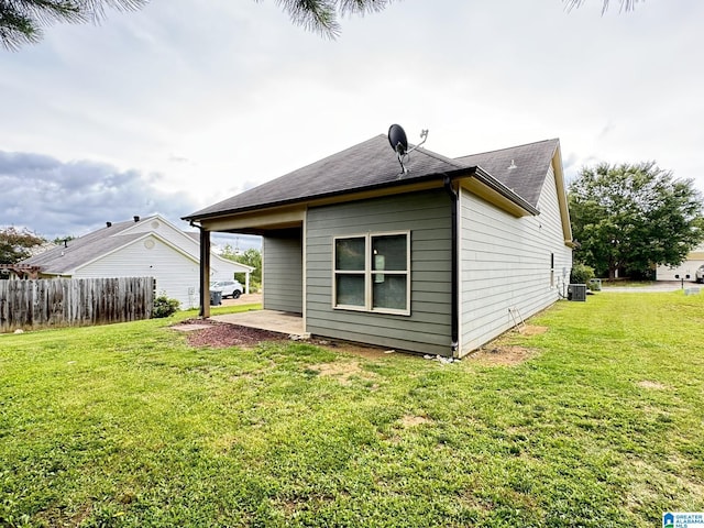 back of property with a yard, central AC, and a patio area