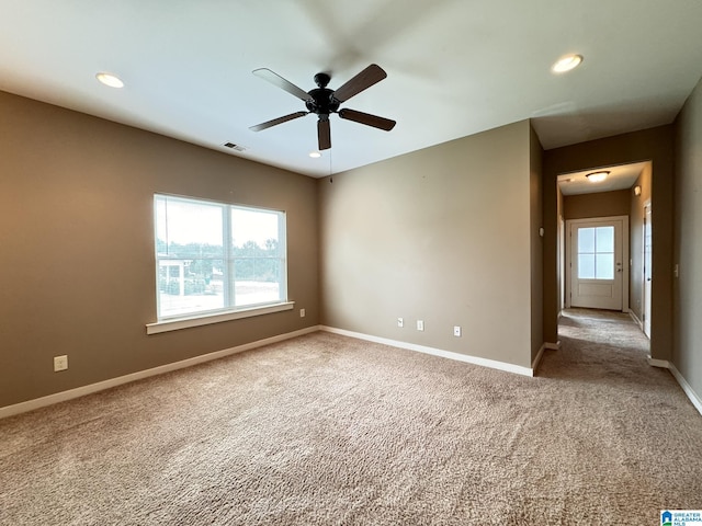 carpeted spare room with plenty of natural light and ceiling fan