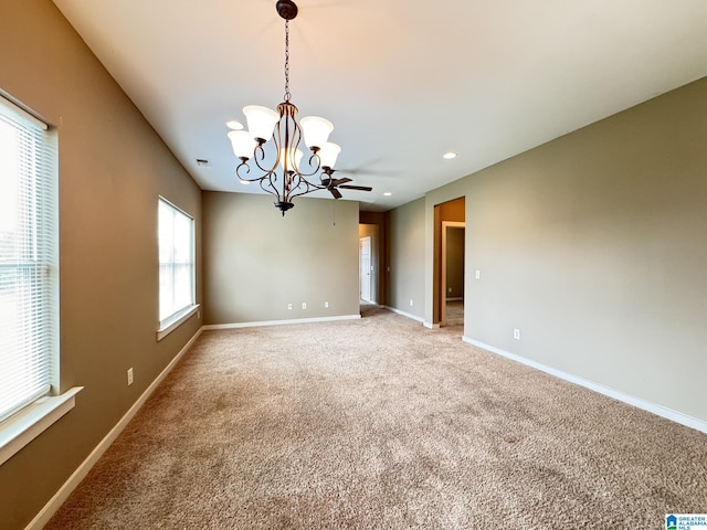 carpeted spare room featuring a notable chandelier