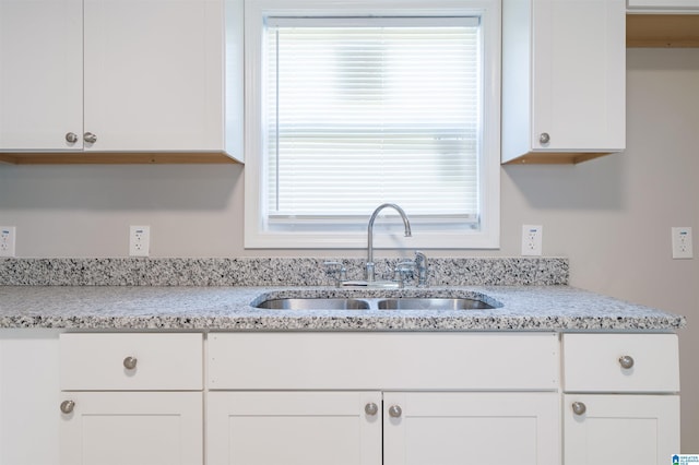 kitchen with white cabinets, plenty of natural light, and sink