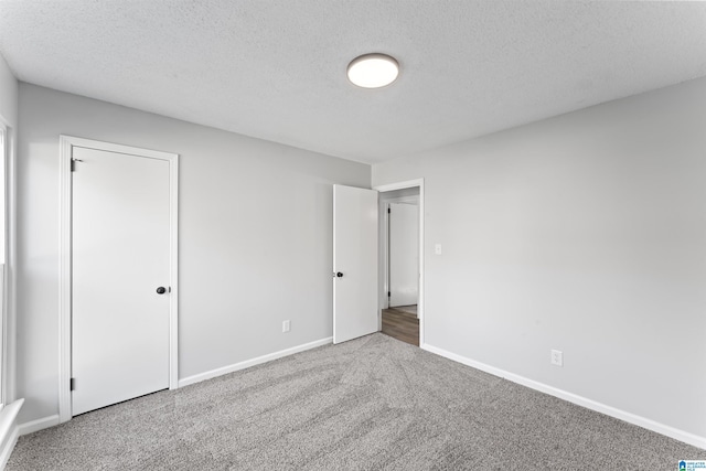 carpeted spare room with a textured ceiling