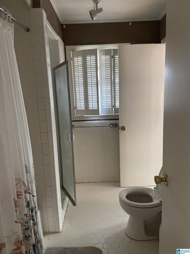 bathroom with tile patterned flooring, curtained shower, and toilet