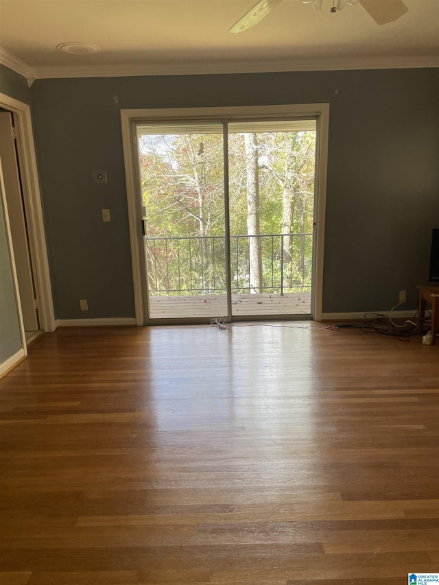 unfurnished living room featuring hardwood / wood-style floors, ornamental molding, ceiling fan, and a healthy amount of sunlight