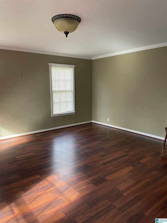 spare room with ornamental molding and dark wood-type flooring