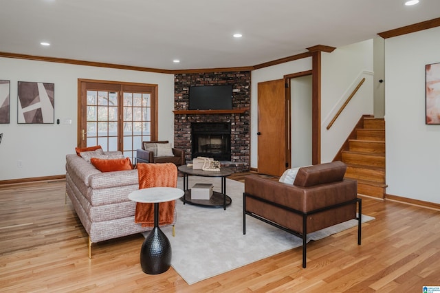 living room with crown molding, a fireplace, and light hardwood / wood-style flooring