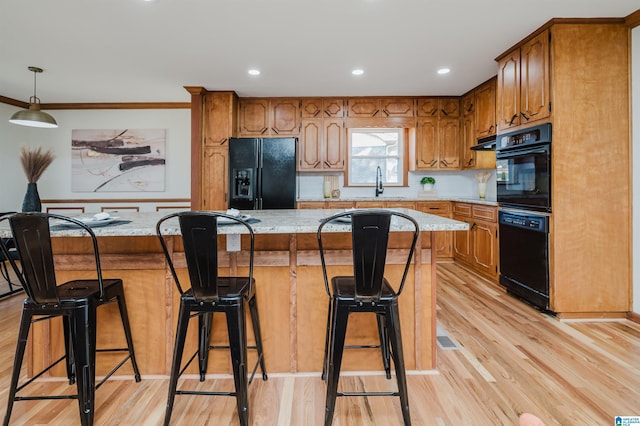 kitchen featuring black appliances, crown molding, light wood-type flooring, and sink