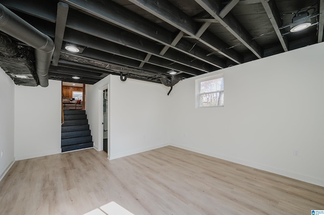 basement with light hardwood / wood-style flooring